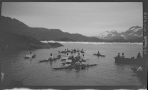 Image: 13 kayakers (seals on one), oomiak [umiak]